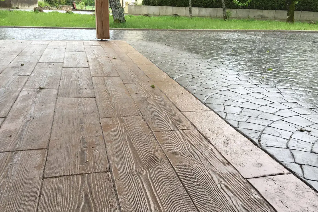 Hormigón impreso con apariencia de madera en el área posterior de un hogar.